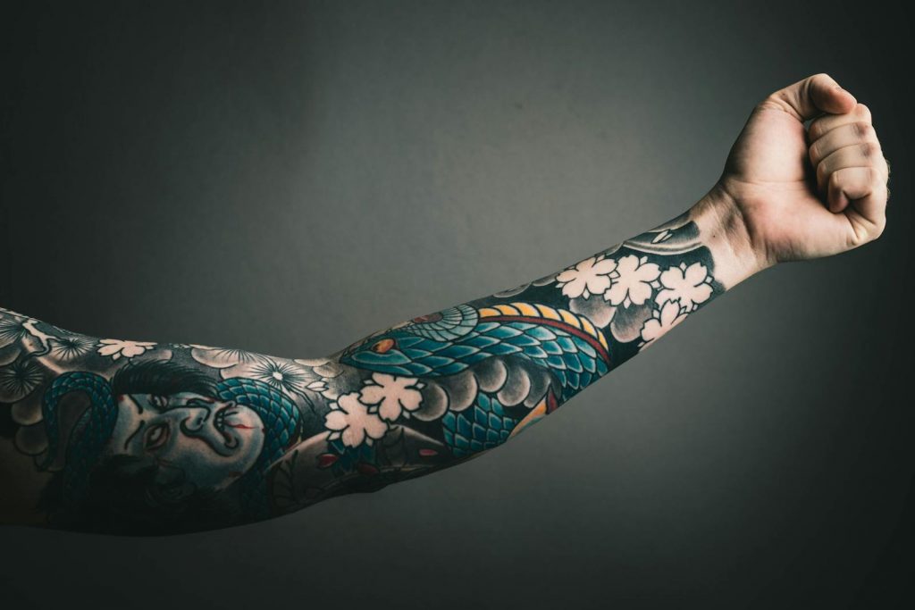 Nahaufnahme eines Armes mit farbigem Sleeve-Tattoo, Japan-Tattoo.