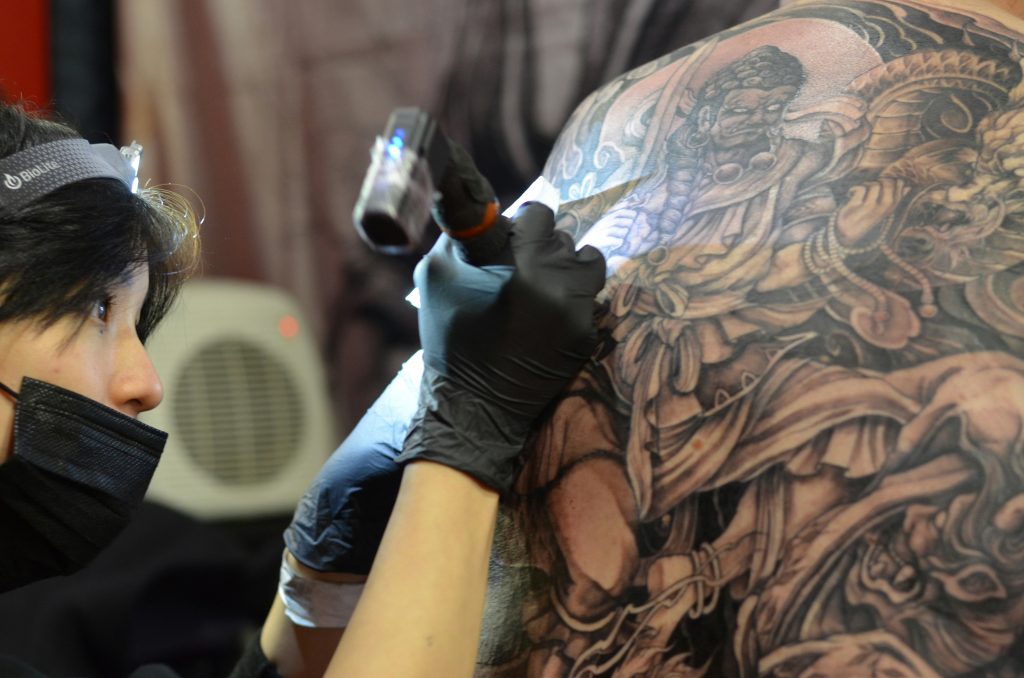 Nahaufnahme eines Rückens, auf den ein Japan-Tattoo gestochen wird.