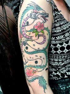 Oberarm-Tattoo mit dem Drachen Haku von Studio Ghibli in Farbe.