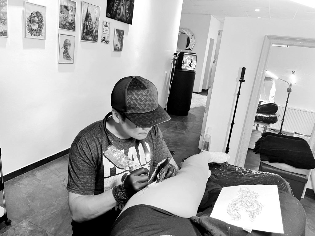 Tätowierer Yuan Li beim Tattoo stechen.