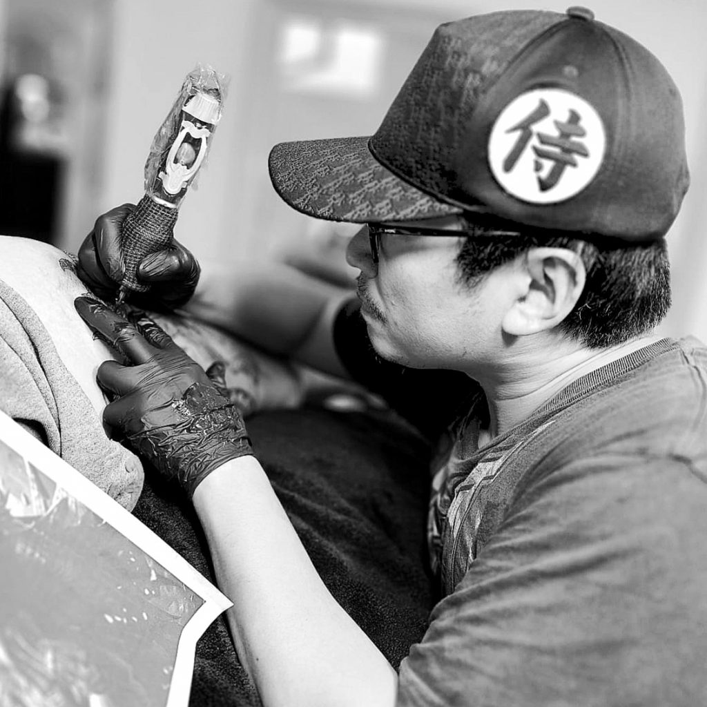 Tätowierer Yuan Li beim Tattoo stechen.