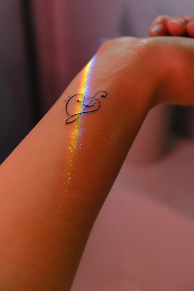 A person with a rainbow tattoo on their arm