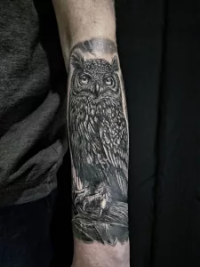 Nahaufnahme eines Unterarms mit einem großen Eulen-Tattoo in Black-and-Grey.