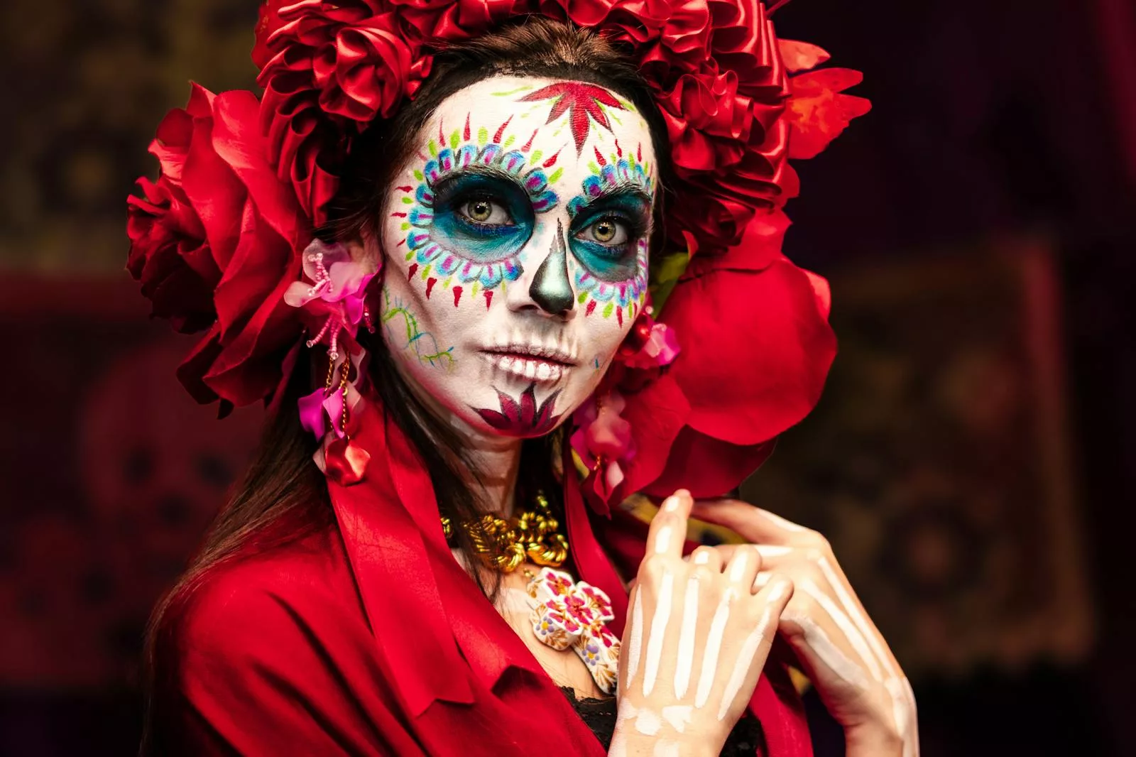A woman adorned in Catrina makeup celebrates Dia de Muertos in Mexico City with vibrant colors and intricate designs.