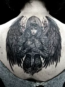 Nahaufnahme eines großen Rücken-Tattoos. Das Tattoo zeigt einen dunklen Engel, der ein Schwert in den Händen hält.