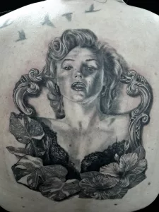 Nahaufnahme eines Rücken-Tattoos. Das Tattoo zeigt ein Porträt von Marylin Monroe.