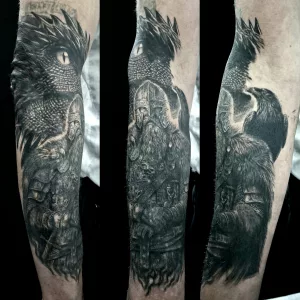Nahaufnahme eines Unterarm-Tattoos. Das Tattoo zeigt einen Wikinger mit Helm und langem Bart, im Hintergrund ist ein Drachenkopf zu sehen.
