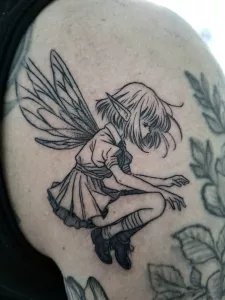 Nahaufnahme eines kleinen Oberarm-Tattoos. Eine kleine fliegende Elfe in black-and-grey.