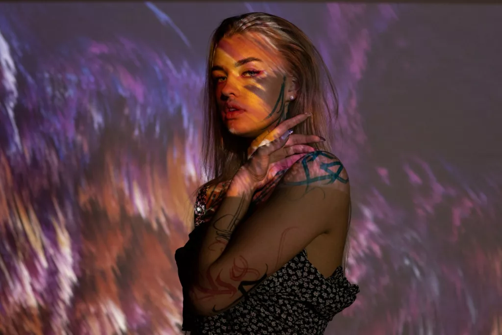 a tattooed woman in a black and white dress is posing for a picture