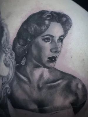 Portrait-Tattoo Nahaufnahme eines Portrait-Tattoos von Elizabeth Taylor in einem schulterfreien Kleid.