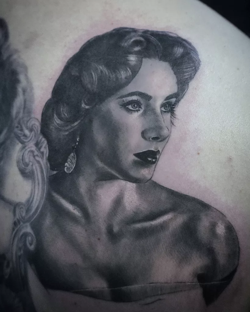 Nahaufnahme eines Portrait-Tattoos von Elizabeth Taylor in einem schulterfreien Kleid.