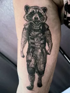 Nahaufnahme eines Oberarm-Tattoos von Rocket Racoon aus Guardians of the Galaxy.