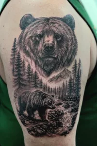 Nahaufnahme eines Oberarm-Tattoos in Black and Grey. Zwei Bären in Waldlandschaft.