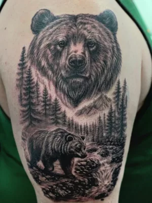 Oberarm-Tattoo_Bären Nahaufnahme eines Oberarm-Tattoos in Black and Grey. Zwei Bären in Waldlandschaft.