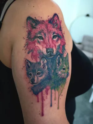 Oberarm-Tattoo_watercolour_Wölfe Nahaufnahme eines bunten Watercolor-Oberarm-Tattoos. Eine Wölfin mit zwei Jungen.