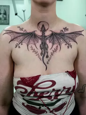 Brust-Tattoo_Drache_black-and-grey Eine Frau mit einem großen Brust-Tattoo in black and grey, das einen fliegenden Drachen zeigt.