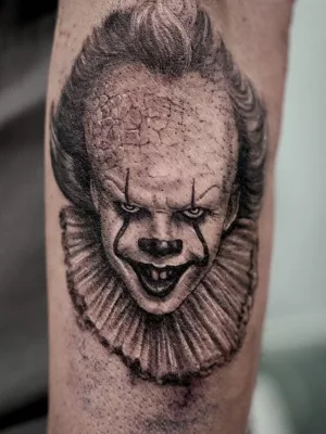 Unterarm-Tattoo_black-and-grey_Pennywise Nahaufnahme eines Unterarm-Tattoos in Black and Grey. Das Tattoo zeigt ein Porträt von Horrorclown Pennywise.