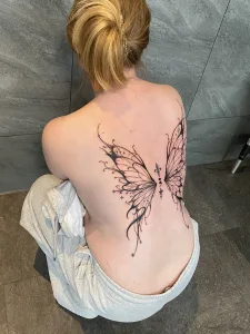 Nahaufnahme eines Großen Rücken-Tattoos in Black and Grey Fineline. Das Motiv zeigt einen stilisierten Schmetterling.